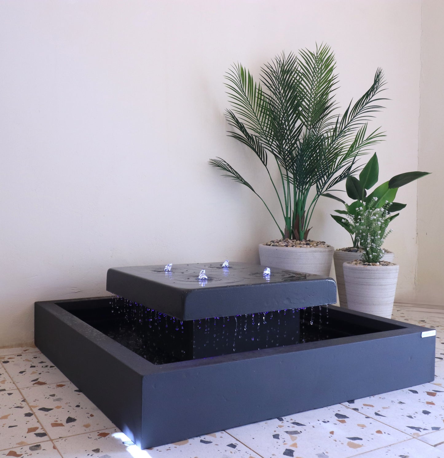 نافورة مربعة متوسطة بإضاءة مدمجة تمنح المكان لمسة هادئة