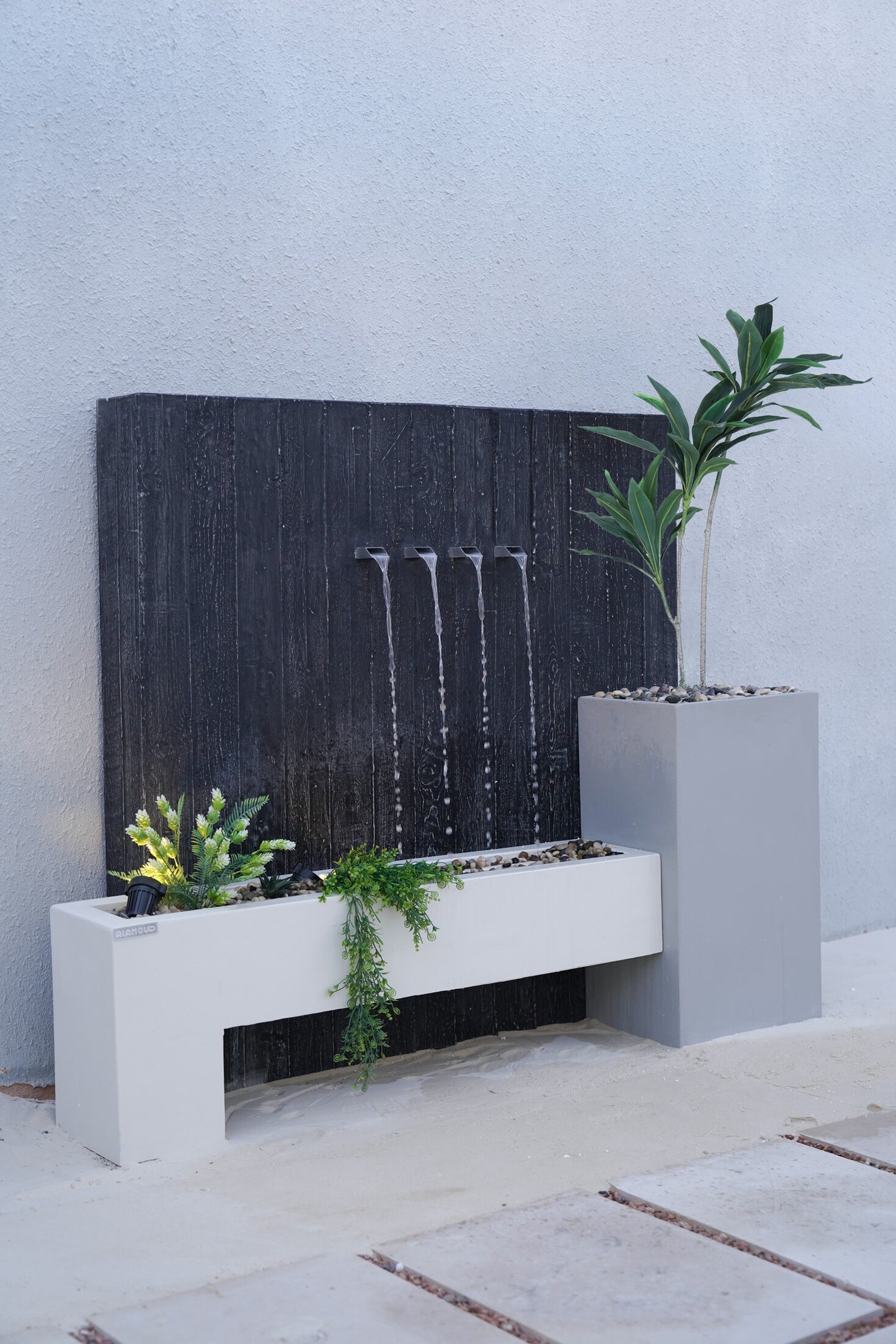 شلال بتصميم متوازن يجمع الحجر والماء والنبات