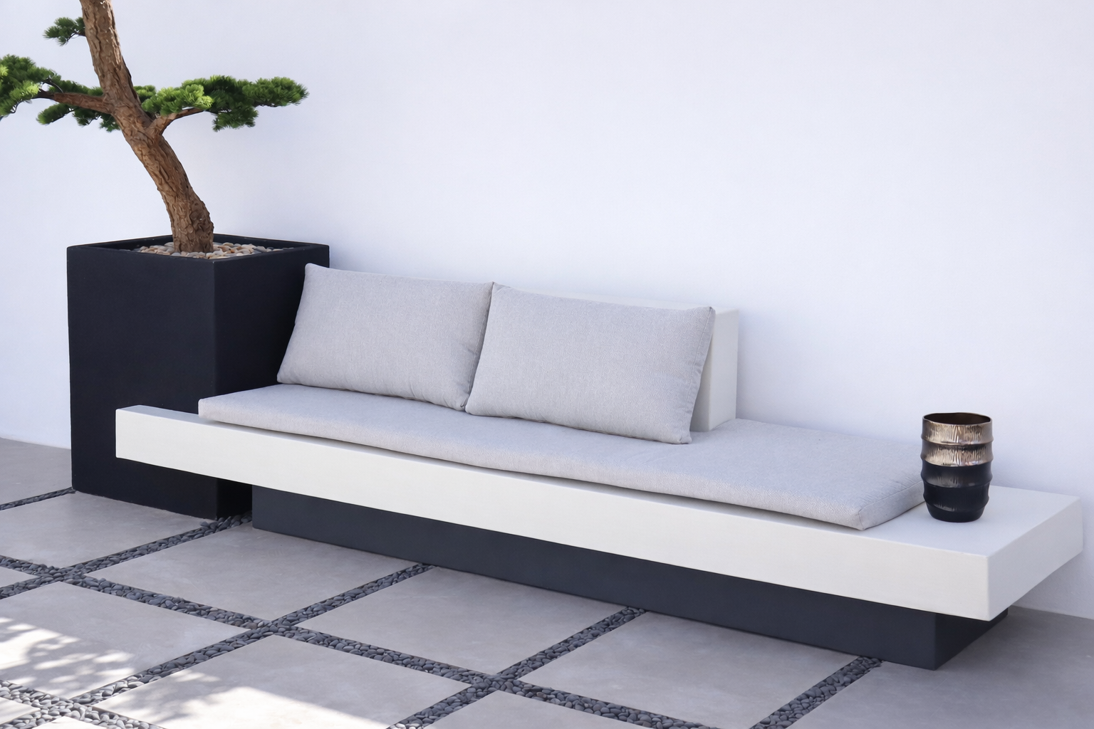 كرسي موري جلسة خارجية بتصميم عصري مع وسائد  ومقعد مدمج بجانب حوض زراعة يحتوي على شجرة بونساي.