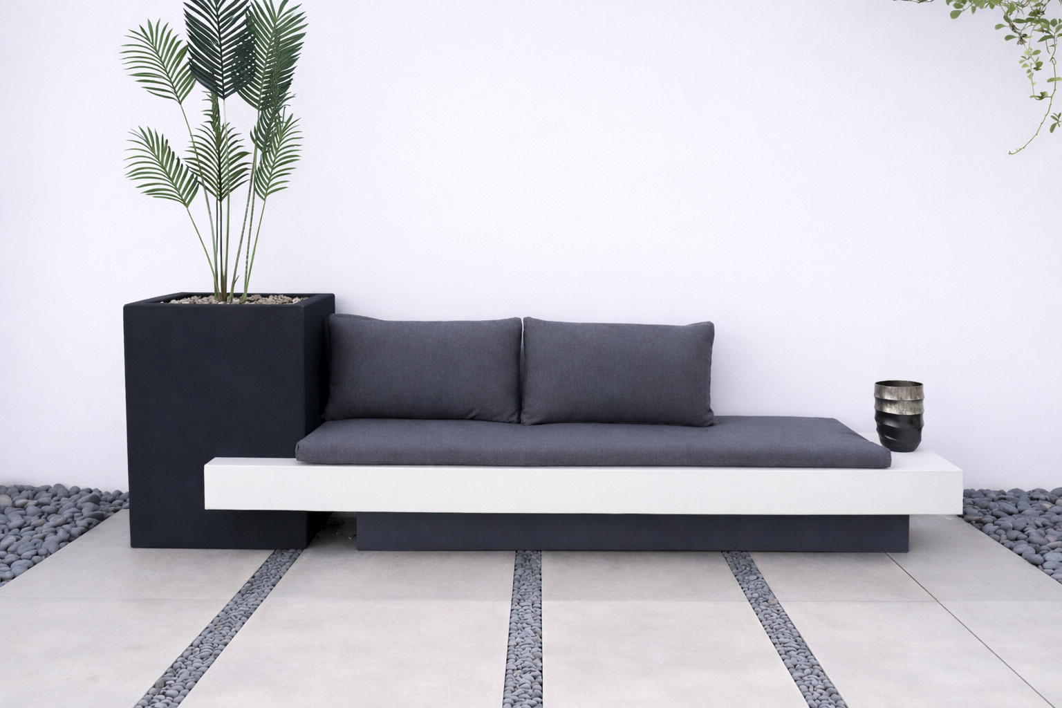 كرسي موري جلسة خارجية بتصميم عصري مع وسائد  ومقعد مدمج بجانب حوض زراعة يحتوي على شجرة النخل.