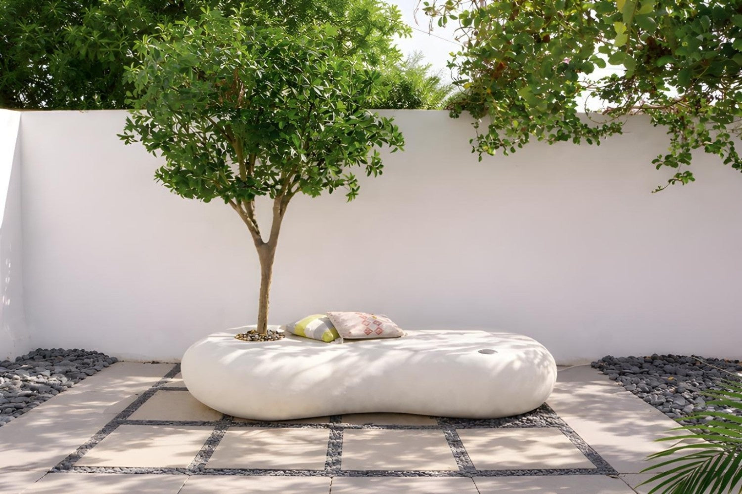 كرسي نيست خارجي بتصميم عصري عضوي بلون أوف وايت مع حوض زراعة مدمج لشجرة ، يجمع بين الجلسة والديكور الطبيعي ليمنح الحدائق والأفنية لمسة أنيقة وهادئة.