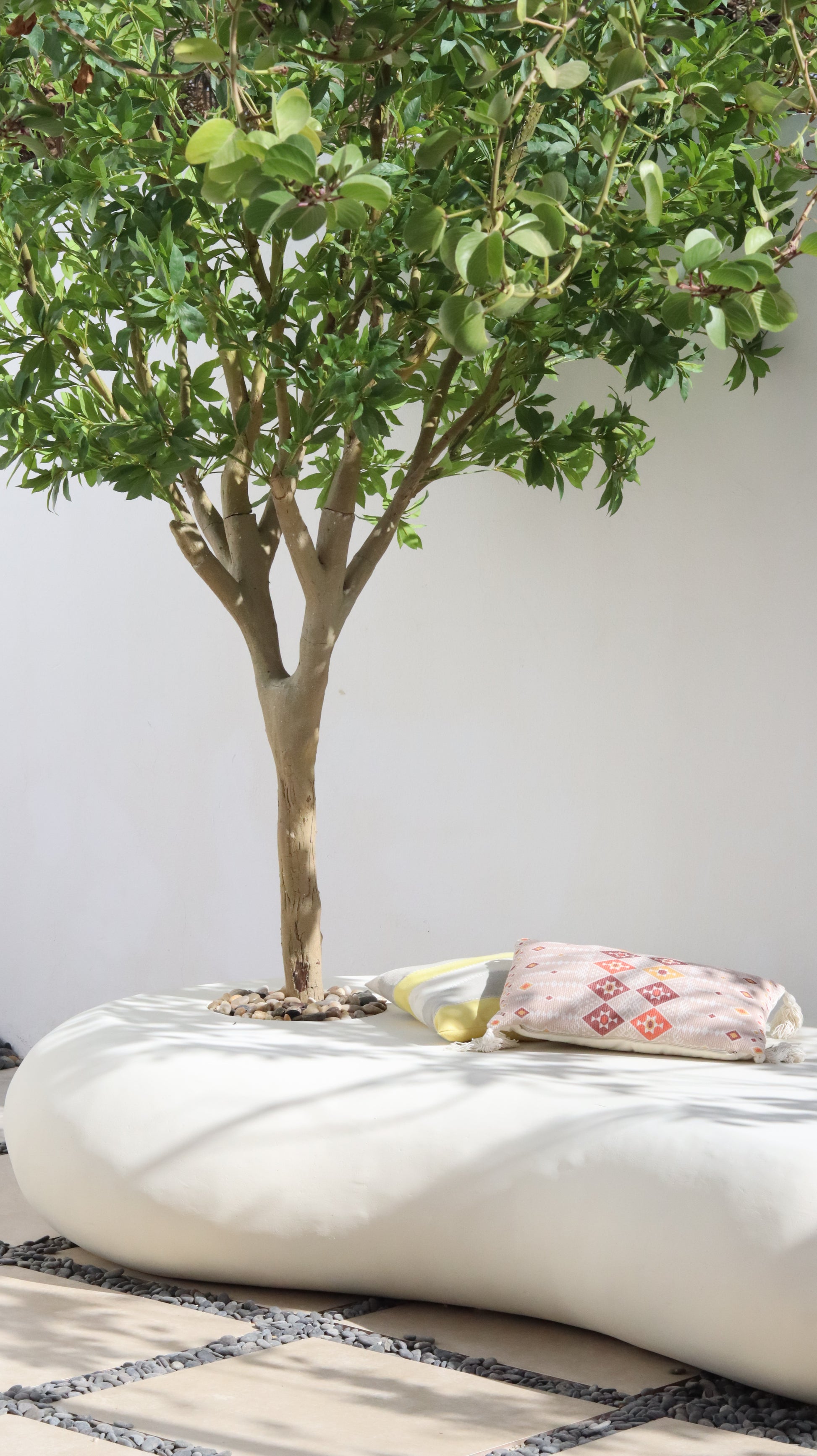 كرسي نيست خارجي بتصميم عصري عضوي بلون أوف وايت مع حوض زراعة مدمج لشجرة ، يجمع بين الجلسة والديكور الطبيعي ليمنح الحدائق والأفنية لمسة أنيقة وهادئة.