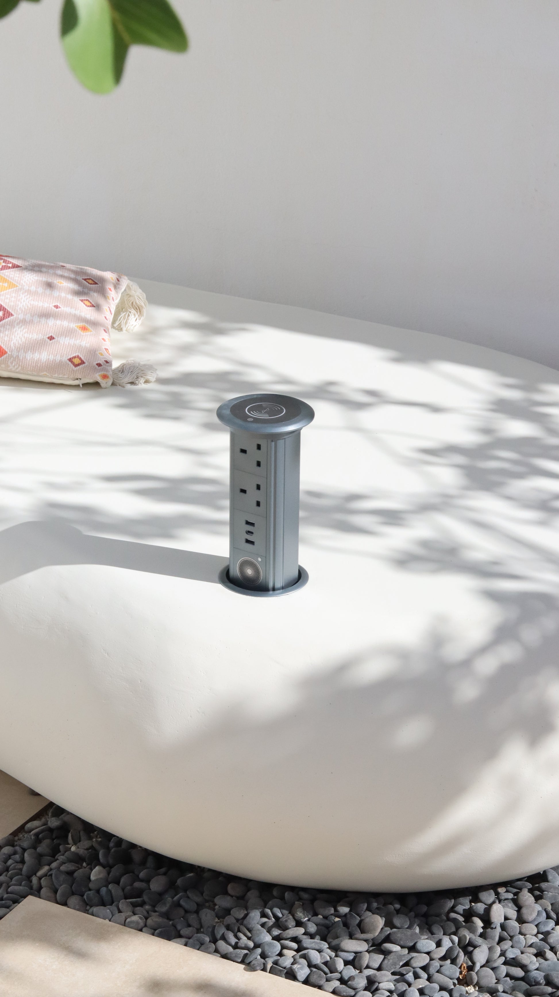 كرسي نيست خارجي  بلون أوف وايت مع شجرة مزروعة ووسائد جلوس، مزود بتوصيلة كهربائية وسماعة مدمجة في فناء حديقة.
